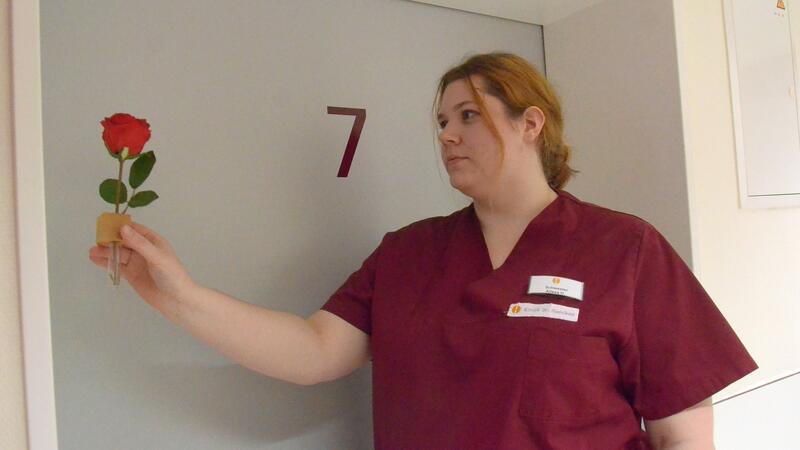 Palliativstation in der Klinik Dr. Hancken: Wo Sterben zum Arbeiten dazugehört Krankenschwester Alissa Heinrich befestigt eine Blume am Türrahmen. Es ist das für alle sichtbare Zeichen für den Tod eines Menschen.