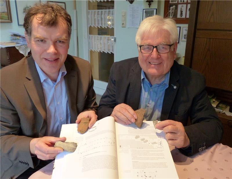 Sensationelle Funde im Düdenbüttel Kreisarchäologe Daniel Nösler (links) und Bürgermeister Heinz Mügge mit Funden und einem holländischen Nachschlagewerk über Hausgrundrisse verschiedener Epochen. Foto Eidtmann