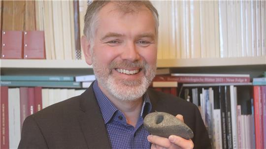 Kreisarchäologe Daniel Nösler mit einer steinzeitlichen Axt.