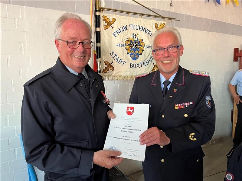Buxtehuder Stadtbrandmeister tritt ab – und verrät Geheimnis des „Feuergangs“ Kreisbrandmeister Peter Winter (rechts) überreicht Horst Meyer die Auszeichnung der Niedersächsischen Innenministerin Daniela Behrens.