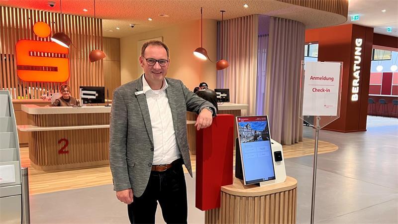 Kreissparkassen-Vorstand Matthias Lühmann im neu gestalteten Servicebereich mit der elektronischen Anmeldung.