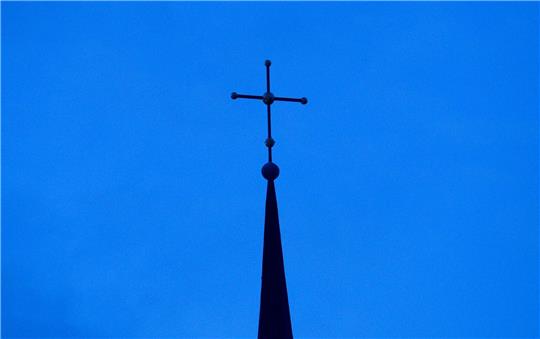 Kreuz einer evangelisch-lutherischen Kirche in der Abenddämmerung.