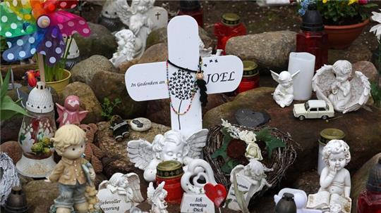 Kreuze, Figuren, Kerzen und Blumen stehen an der Stelle, wo der sechsjährige getötete Joel gefunden wurde. Der Prozess wegen Totschlags geht weiter.