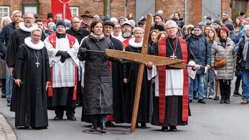 Kristina Herbst (l), Präsidentin des Schleswig-Holsteinischen Landtags, und Christoph Giering, katholischer Dekan, führen den Kreuzweg an.