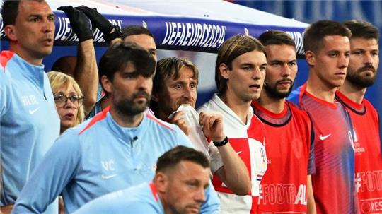 Kroatiens Luka Modric (M) und seine Teamkollegen schauen vom Spielfeldrand zu.