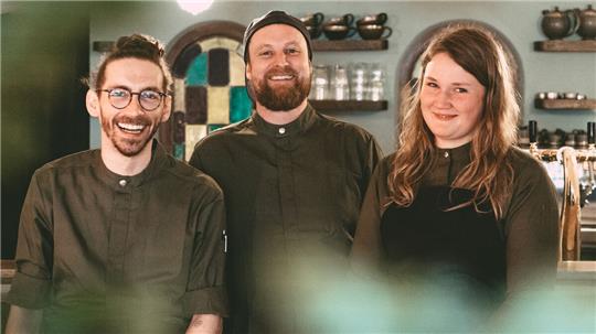 Küchenchef Jonatan Scharf (Mitte) und sein Serviceteam, Katharina Rusch und Phil Bohnhof, freuen sich, dass es nun endlich losgeht. Foto: Schuster
