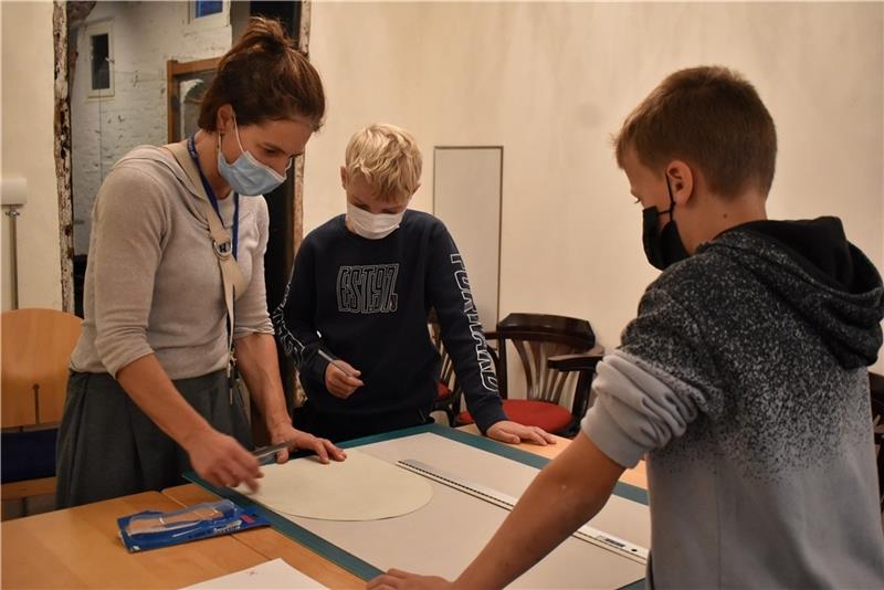 Ahlerstedter Schüler auf Entdeckungsreise im Agathenburger Schloss Kulturvermittlerin Karin Haenlein hilft Finn und Max beim Zuschneiden der Wappenform.