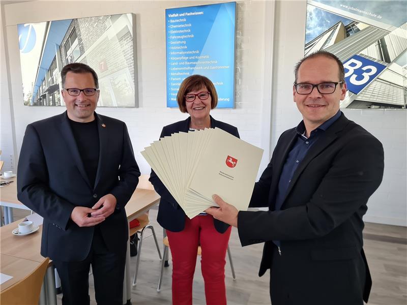 Kultusminister Grant Hendrik Tonne übergibt die Förderbescheide im Beisein von Landtagsmitglied Petra Tiemann an Landrat Kai Seefried (von rechts). Foto: LK Stade/Beneke