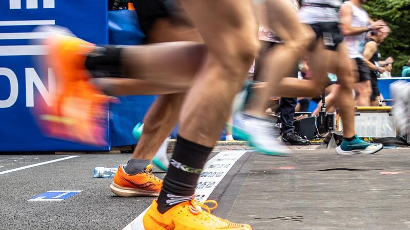 Läufer überschreiten eine Startlinie.