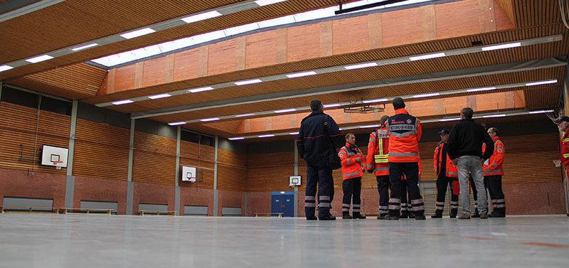 Lagebesprechung vor Ort: Mitarbeiter des Landkreises, vom Deutschen Roten Kreuz und der Johanniter-Unfall-Hilfe begutachten die BBS-Turnhalle an der Glückstädter Straße. Foto Stephan