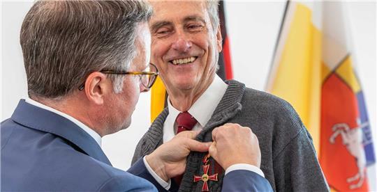 Landrat Kai Seefried heftet Gert Dahms das Bundesverdienstkreuz an die Brust.