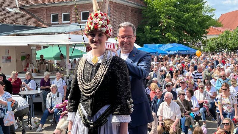 Landrat Kai Seefried legt der neuen Altländer Blütenkönigin in Jork auf dem Blütenfest die silberne Filigrankette um.