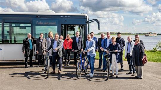 Landrat Kai Seefried und die Vertreter der Kommunen, Partner und Sponsoren vor dem Elbe-Radwanderbus am Lühe-Anleger.