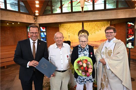 Landrat Kai Seefried verleiht Marie und Wolf-Dieter Friedrich die Niedersächsische Medaille für vorbildliche Verdienste um den Nächsten – hier mit Dechant Johannes Pawellek nach dem Gottesdienst in Buxtehude. Foto: Landkreis Stade / Daniel Beneke