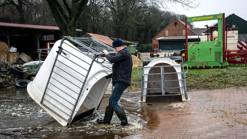 Landwirt Carsten Schnakenberg zieht Kälberställe aus dem Wasser auf seinem Hof.