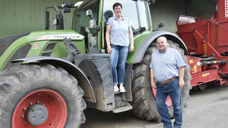 Elke Wiebusch steht auf einem Traktor und ihr Bruder Johann Höft davor.