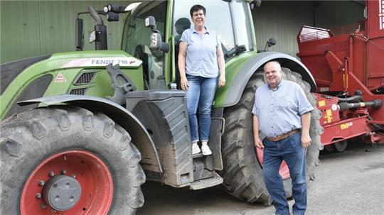 Elke Wiebusch steht auf einem Traktor und ihr Bruder Johann Höft davor.