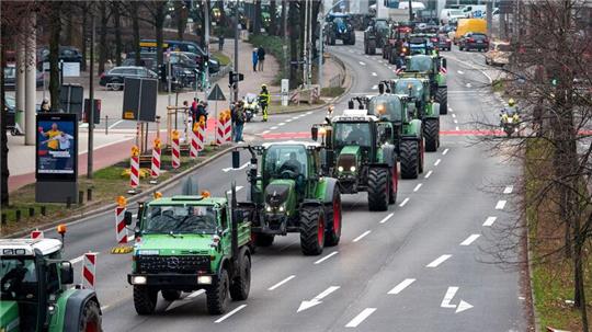 Landwirte fahren mit Traktoren und landwirtschaftlichen Fahrzeugen durch die Innenstadt.