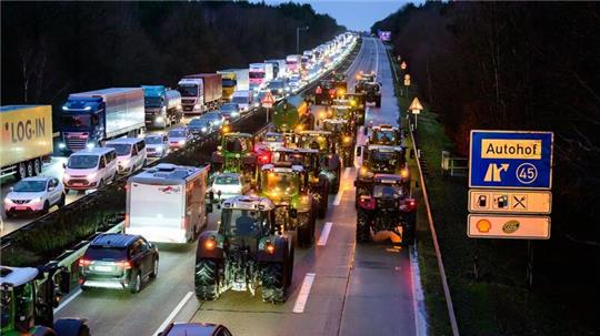 Landwirte fahren mit ihren Treckern auf der Autobahn 7 zwischen Soltau und Hannover. Foto: Philipp Schulze/dpa
