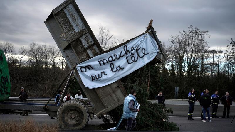 Landwirte kippen Zweige und Äste auf die Fahrbahn, während sie eine Autobahn in der Nähe von Lyon blockieren.