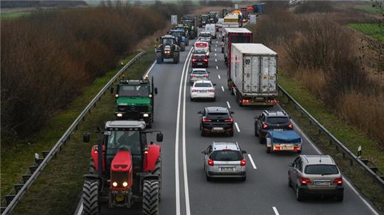Landwirte protestieren und fahren mit ihren Treckern nahe des Wesertunnels.