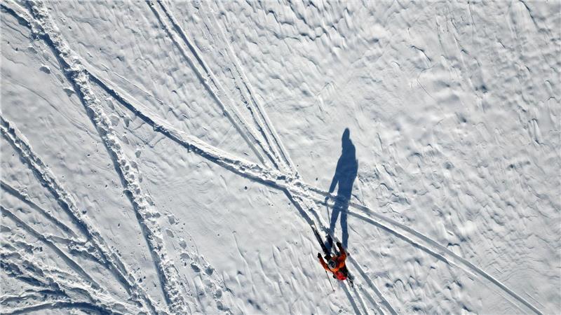 Lange Schatten im Schnee - Wintersportler an der Rodelpiste am Wurmberg im Harz