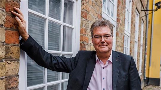 Lars Harms, Landtagsabgeordneter des Südschleswigschen Wählerverbandes (SSW), lehnt an einer Hauswand in der Innenstadt.