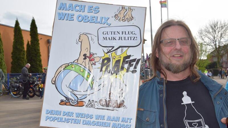 Lars Laengner demonstriert mit Comic-Plakat gegen die AfD: Obelix vertrimmt darauf den AfD-Kreisvorsitzenden Maik Julitz.