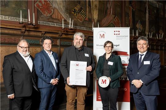 Lars Lichtenberger und Anna von Bargen (3. und 4. von links), Vorstandsmitglieder des „Kehdinger Küstenschiffahrts-Museum“, nahmen in Lüneburg das Gütesiegel in Empfang. Überreicht hatten es Staatssekretär Joachim Schachtner (links), Johan