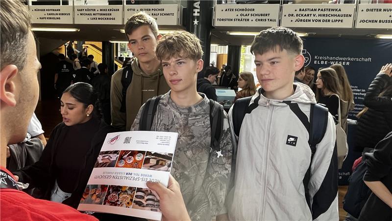Werben um Azubis: Wenn Top Gun plötzlich im Stadeum auftaucht Lasse, Jonas und Phil informieren sich am Stand von Eisbär-Eis.