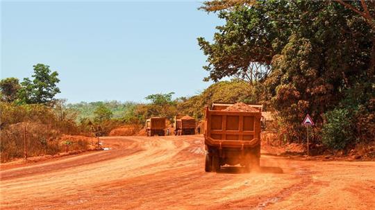 Lastwagen transportieren Bauxit entlang einer Bergbau-Transportstraße. Laut einer Studie werden mehr als ein Drittel der Menschenaffenpopulation in Afrika durch Bergbau gefährdet.