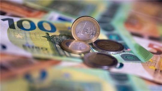 Geldscheine mit dem Wert von 100 und 50 Euro und Münzen liegen auf einem Tisch. 