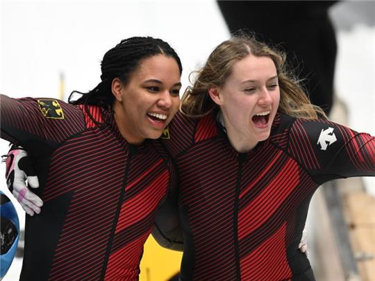 Laura Nolte (rechts) und Deborah Levi jubeln nach dem letzten Durchgang über den Olympiasieg im Zweierbob. Foto: Robert Michael/dpa-Zentralbild/dpa