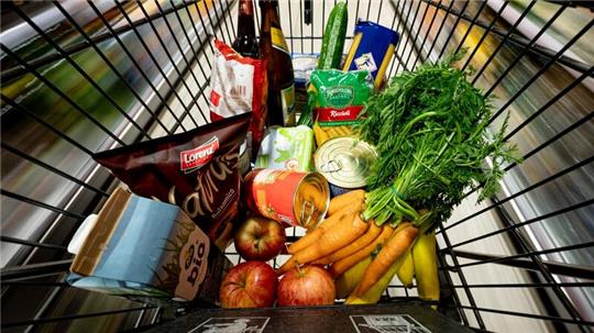 Lebensmittel liegen in einem Einkaufswagen in einem Supermarkt.