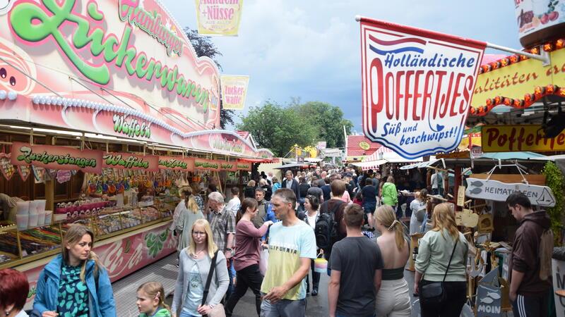 Leckere Versuchungen überall entlang der Buden auf mehr als 1300 Meter Länge: Zuckerstangen links, knusprige holländische Süßkartoffelpommes rechts.