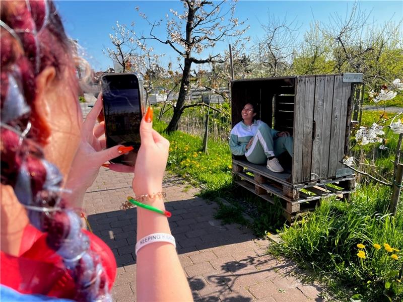 Leia Munnelly aus London posiert in der Apfelkiste, ihre Kollegin hält für Instagram drauf – Hashtag #Herzapfelhof. Foto: Richter
