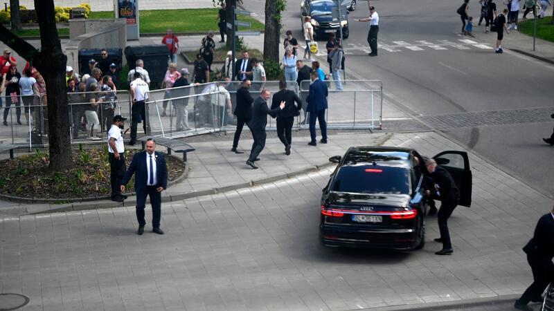 Leibwächter bringen den slowakischen Ministerpräsidenten Robert Fico in einem Auto vom Ort des Geschehens in Sicherheit.