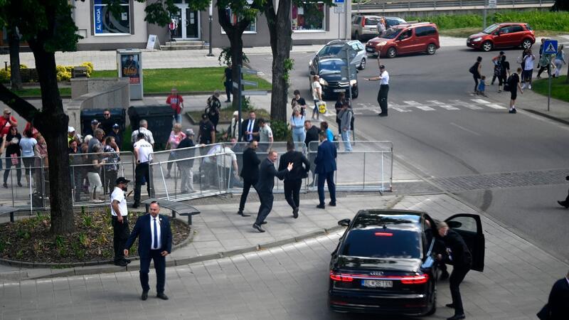 Leibwächter bringen den slowakischen Regierungschef Robert Fico nach dem Attentat in einem Auto in Sicherheit.