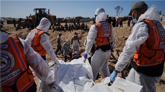 Kreise: Tote und Verletzte bei Angriff im Gazastreifen Leichen nicht identifizierter Palästinenser, die aus Israel zurückgekehrt sind, werden in einem Massengrab in Deir al-Balah im Gazastreifen begraben.