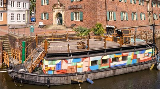 Kunstkudder an seinem Liegeplatz im Alten Hansehafen mit dem Schwedenspeicher im Hintergrund