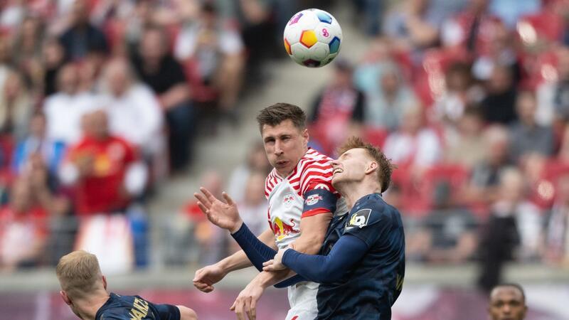 Leverkusen gewinnt wieder spät, Bayern verliert Leipzigs Willi Orban (M) im Kopfball-Duell mit dem Mainzer Sepp van den Berg.