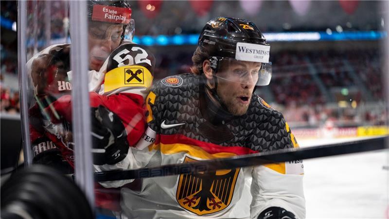 Trotz DEB-Sieg gegen Österreich: Viertelfinal-Chancen sinken Leon Hüttel (r) kämpft mit dem Österreicher Paul Huber um den Puck.