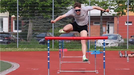 Leon Scheffer vom Buxtehuder SV springt über eine Hürde auf einer Tartanbahn.