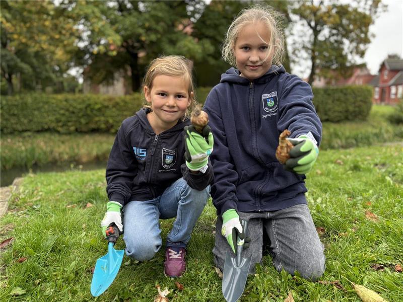 Leonie (links) und Bente haben in Bützfleth Blumenzwiebeln eingesetzt.