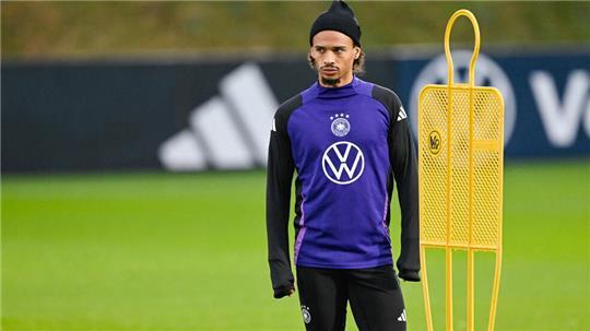 Leroy Sané steht auf dem Spielfeld.
