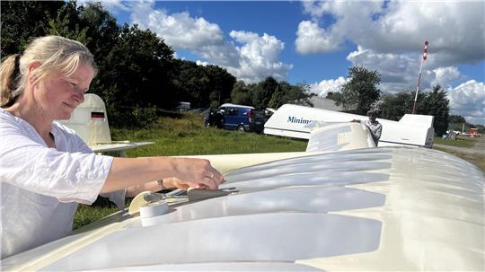 Letzte Vorbereitungen für den Erstflug nach der Flügel-Restaurierung. Im Hintergrund der Transportanhänger für die Minimoa.
