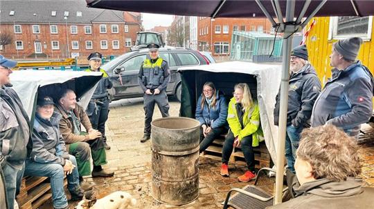 Letzter Tag im Protestcamp: Die Landwirte haben sich zur Abschlussrunde mit der Polizei um die Feuertonne versammelt.