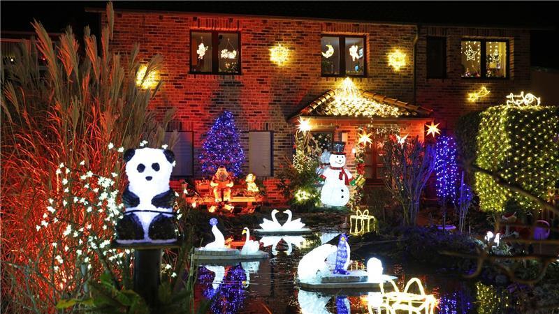 Leuchtende Figuren stehen im Vorgarten umgeben von zahlreichen weiteren Lichtern, die das Weihnachtshaus der Familie Lange erstrahlen lassen. Das Haus wird zur Adventszeit traditionell mit tausenden bunten Lichtern geschmückt.