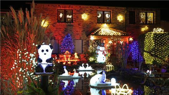 Leuchtende Figuren stehen im Vorgarten umgeben von zahlreichen weiteren Lichtern, die das Weihnachtshaus der Familie Lange erstrahlen lassen. Das Haus wird zur Adventszeit traditionell mit tausenden bunten Lichtern geschmückt.