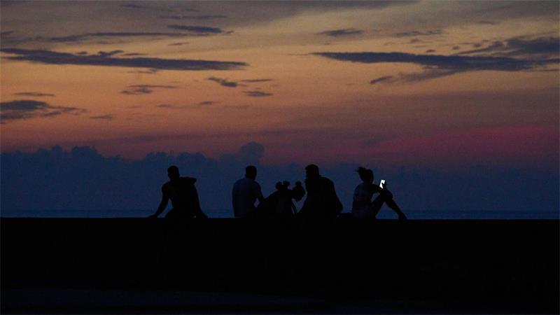 Leute sitzen während eines Stromausfalls auf dem Malecón in Havanna.